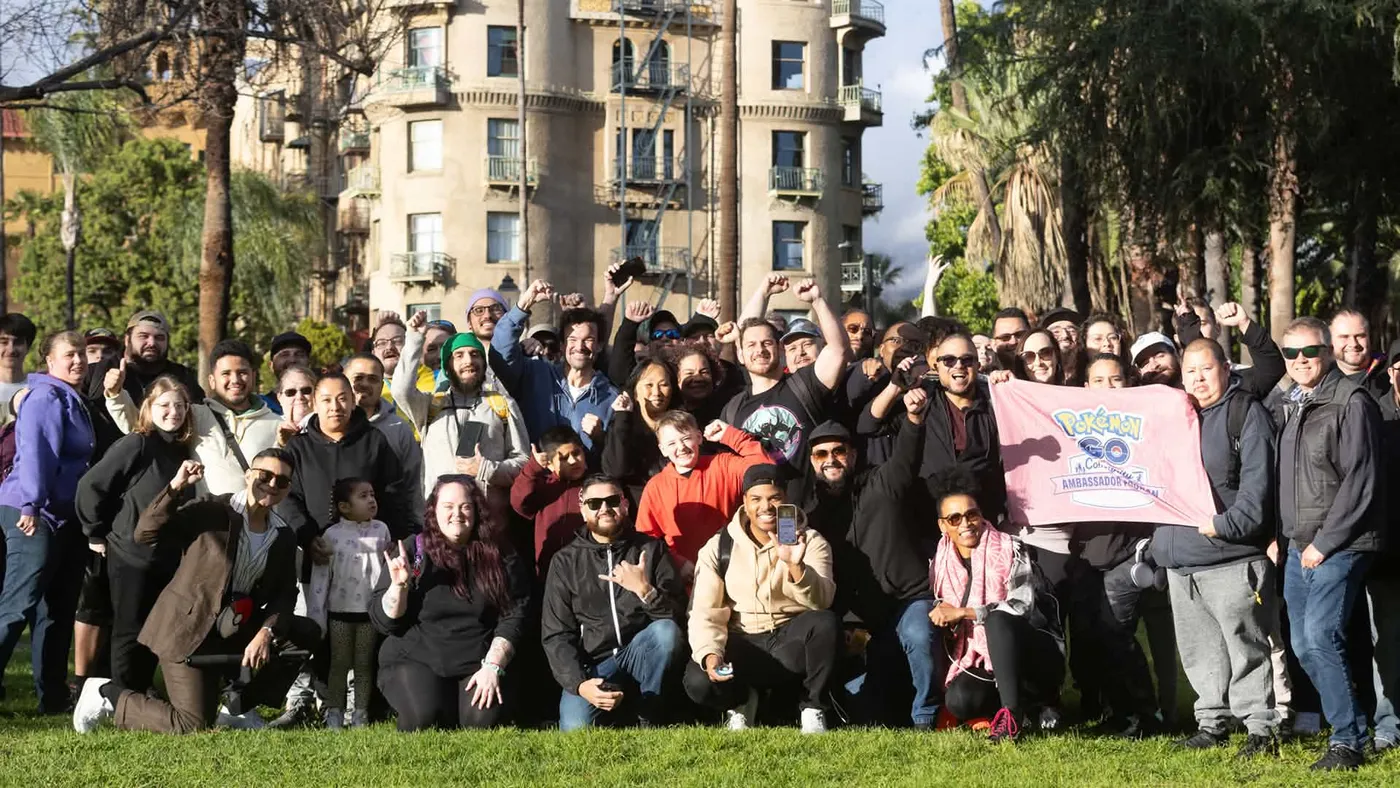 A big group of Pokémon GO players cheering at a meetup