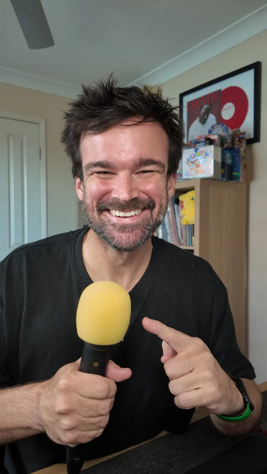 Matt holding a microphone at his desk